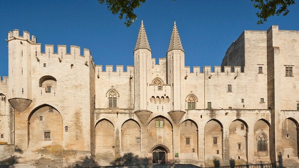Un château historique doté de nombreuses tours et de fenêtres en arc.