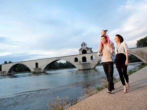A stone bridge over a river with a small bell tower, a paved walkway, and greenery in the background. - hotelF1 Avignon Centre Courtine Gare TGV (Avignon)