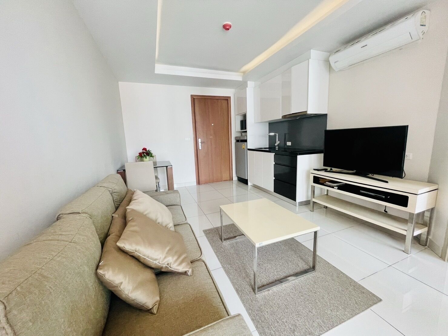 A modern living room with a sofa, a coffee table, and a TV stand.