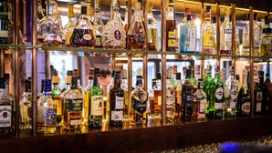 Un bar con varias botellas de licores exhibidas en estantes.