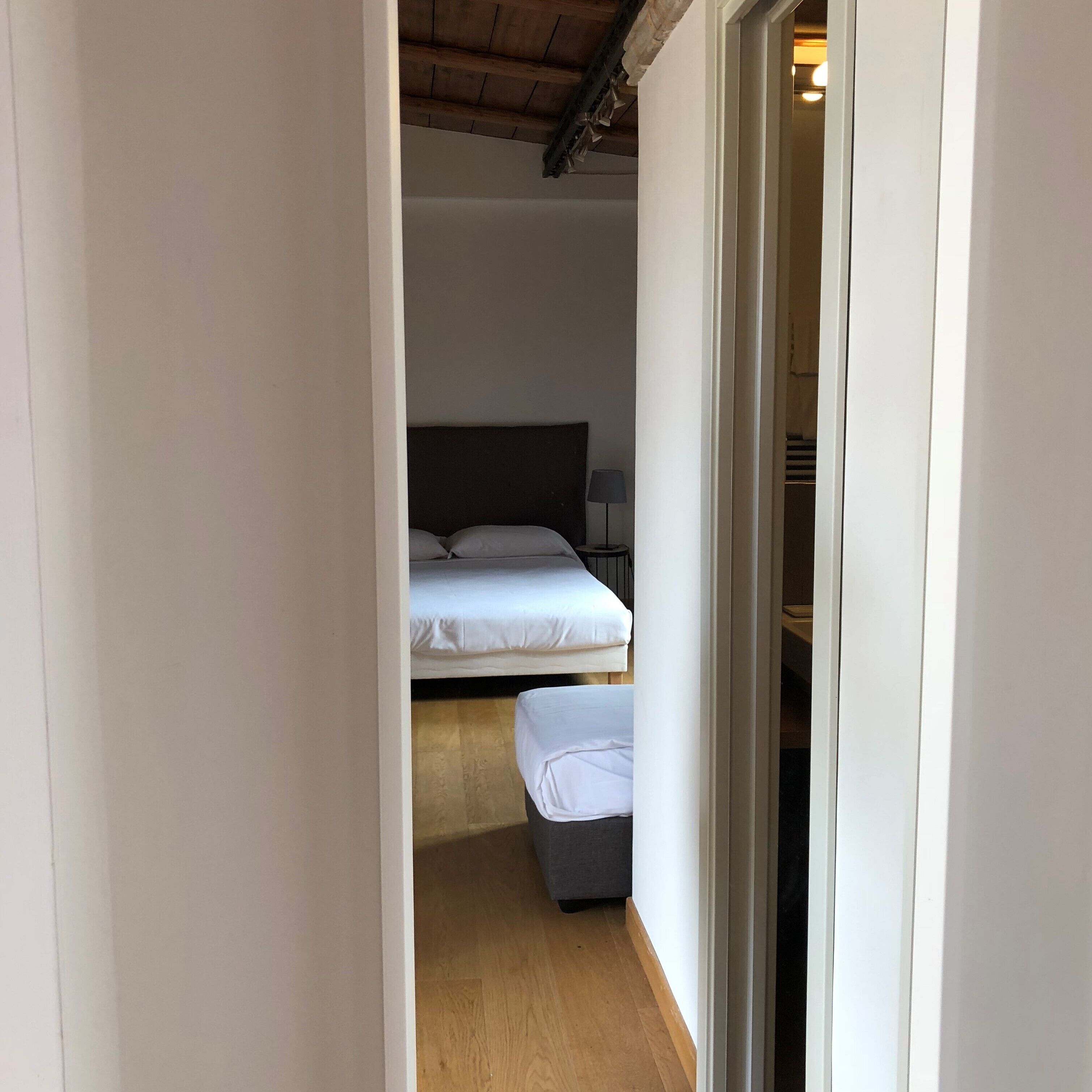 A bedroom with a bed, bedside table, and a small bench.