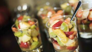 A series of clear glasses containing layered fruit parfaits.