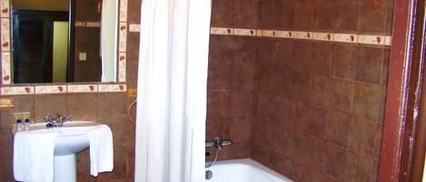 Un baño con lavamanos, espejo y bañera.