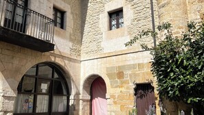 A courtyard with stone buildings, a central archway, and a small balcony. - Posada Torre-Palacio de los Alvarado (Merindad de Montija)