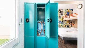 Une chambre avec une armoire de couleur turquoise, un lit superposé et un mur décoré d’affiches de voyage.