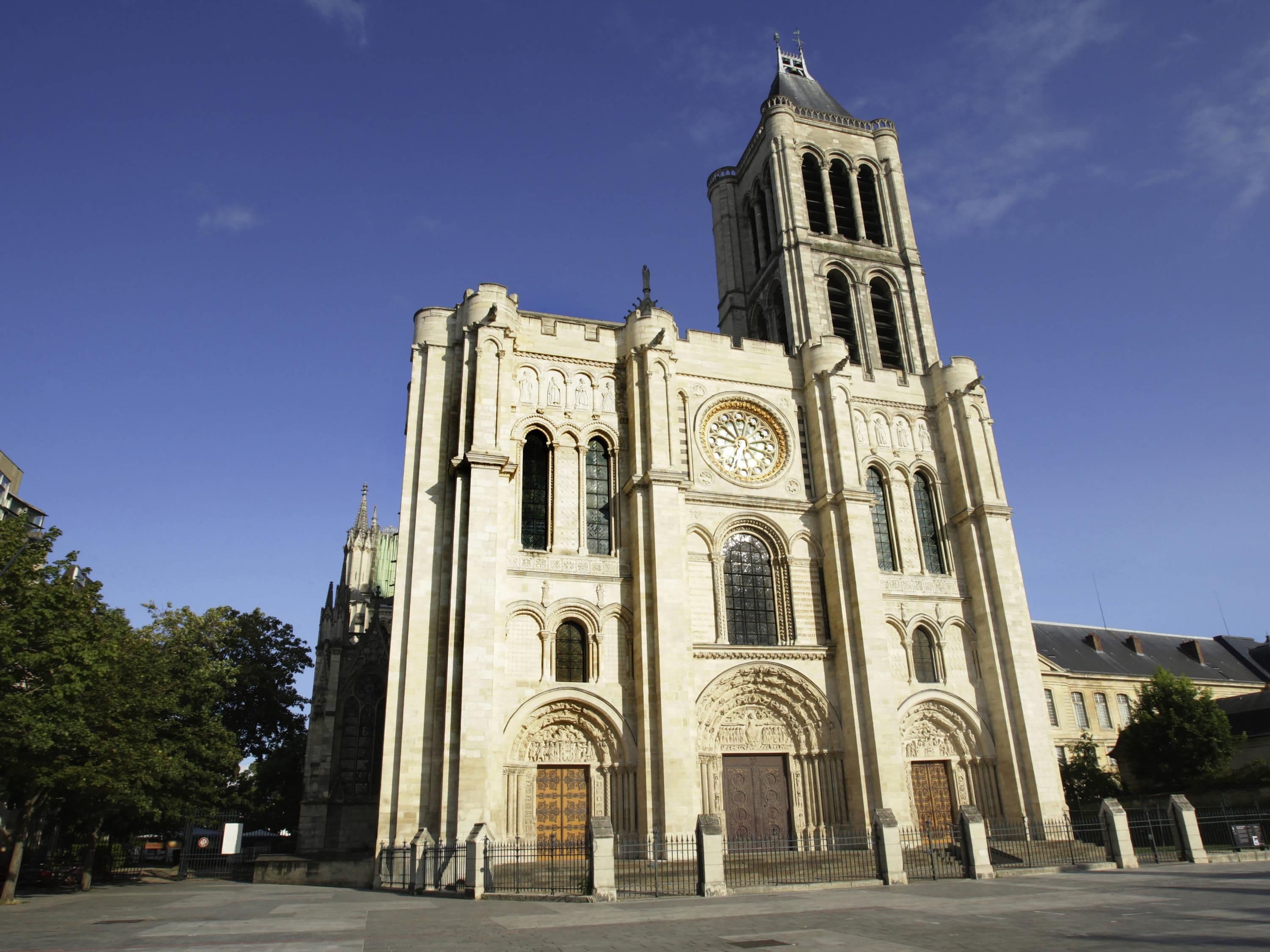 Una gran catedral con una imponente torre del reloj y una fachada detallada.