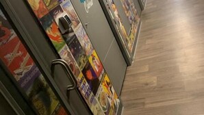 En hotelgang med døre nummereret 20 og 21, hver udsmykket med farverige plakater.
