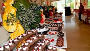 A buffet with various desserts and a large yellow statue. - Magic Sun Hotel (Kemer)