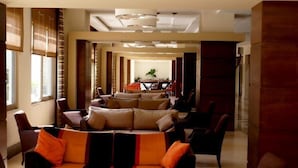 A spacious lounge area with a sofa set, chairs, and a dining table in the background. - Magic Sun Hotel (Kemer)