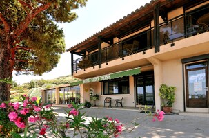 Un hotel con balcón, mobiliario exterior y un cartel que dice "HOTEL SAINT PIERRE".