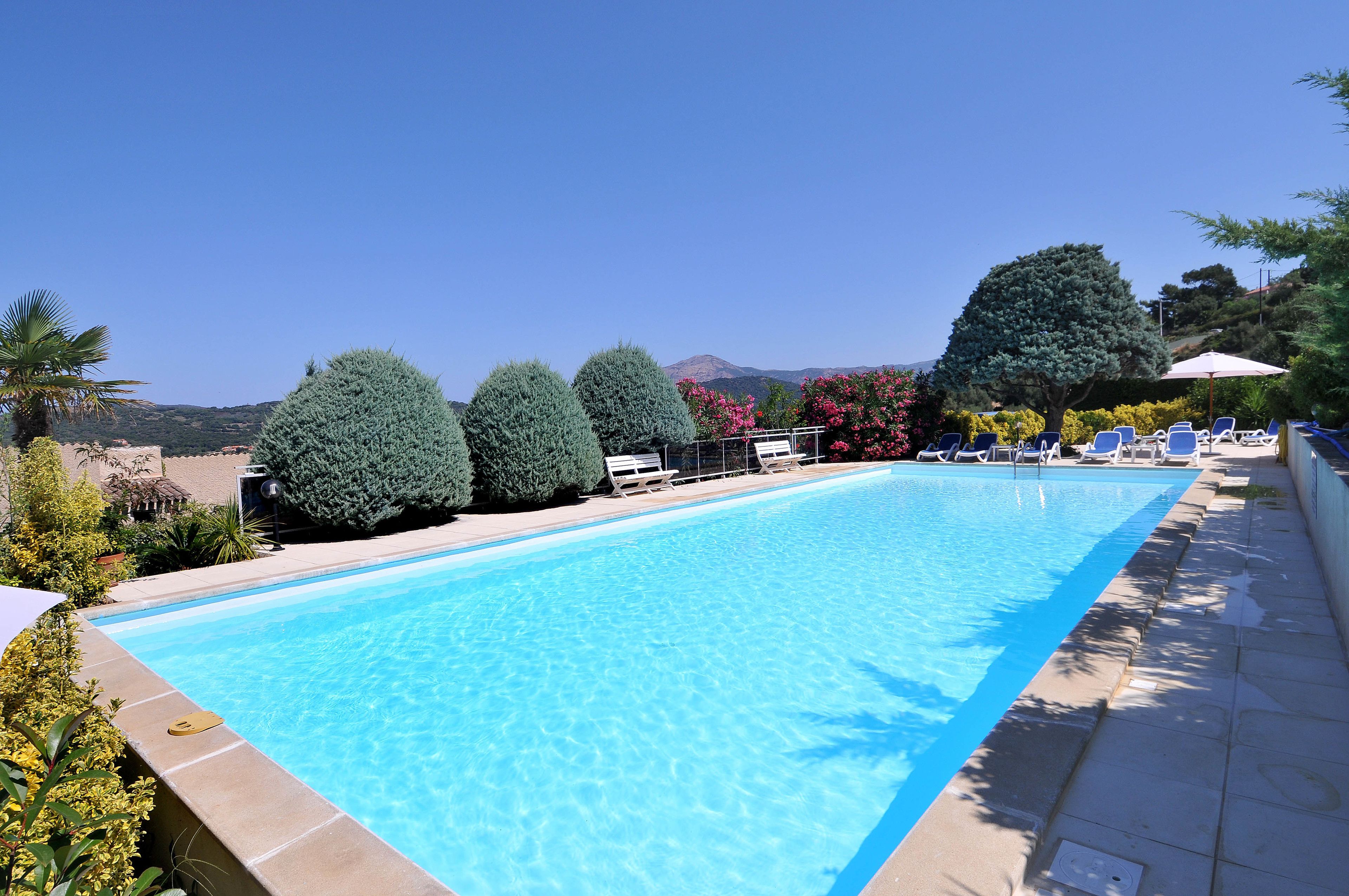 Utomhuspool, parasoller och solstolar