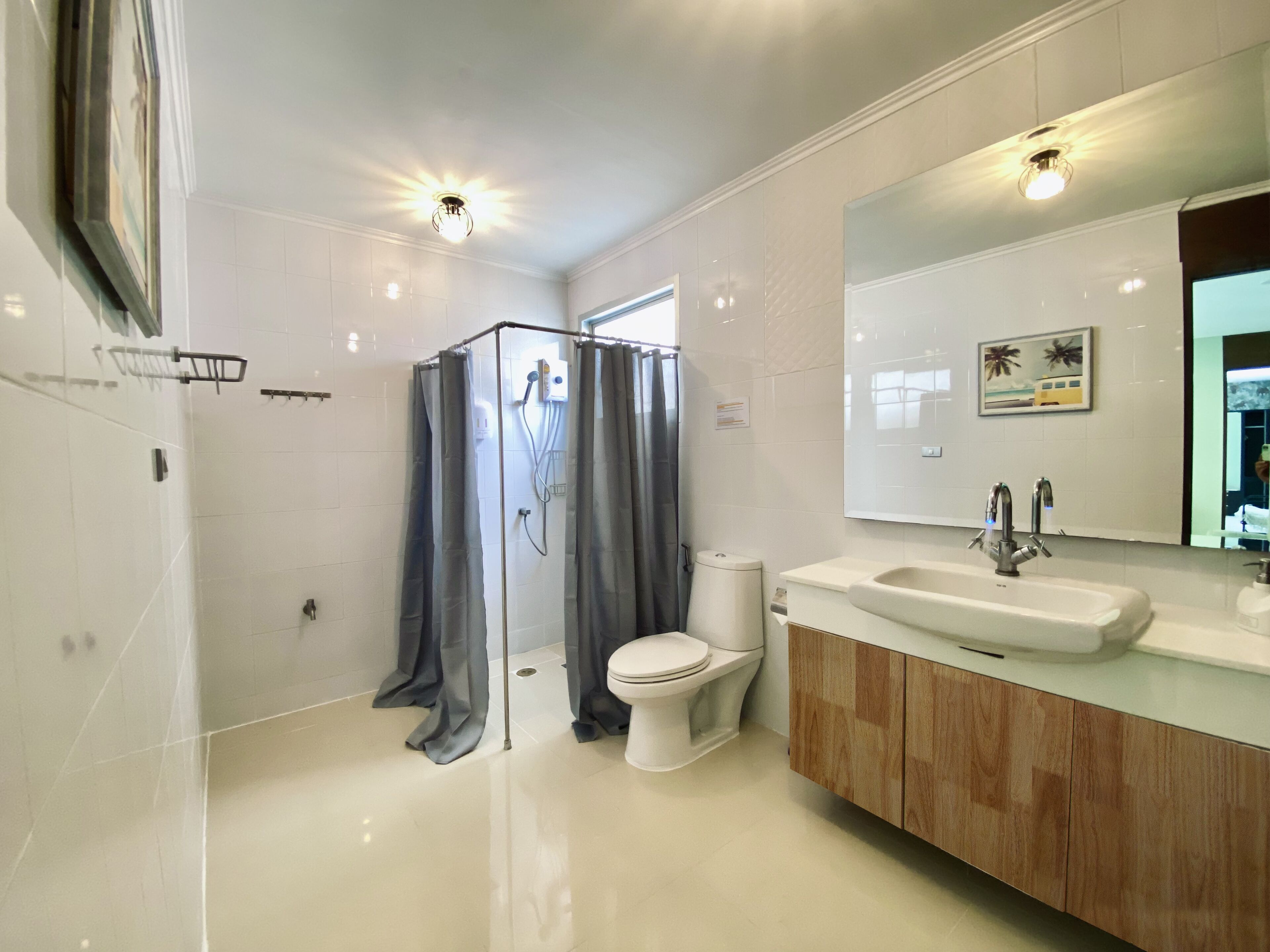 A modern bathroom with a glass shower enclosure, a toilet, and a vanity with a sink and mirror.