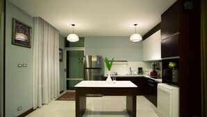 A modern kitchen with a central island, stainless steel appliances, and pendant lighting. - Nagawari Art Maldives BBQ Pattaya Villa (Sattahip)