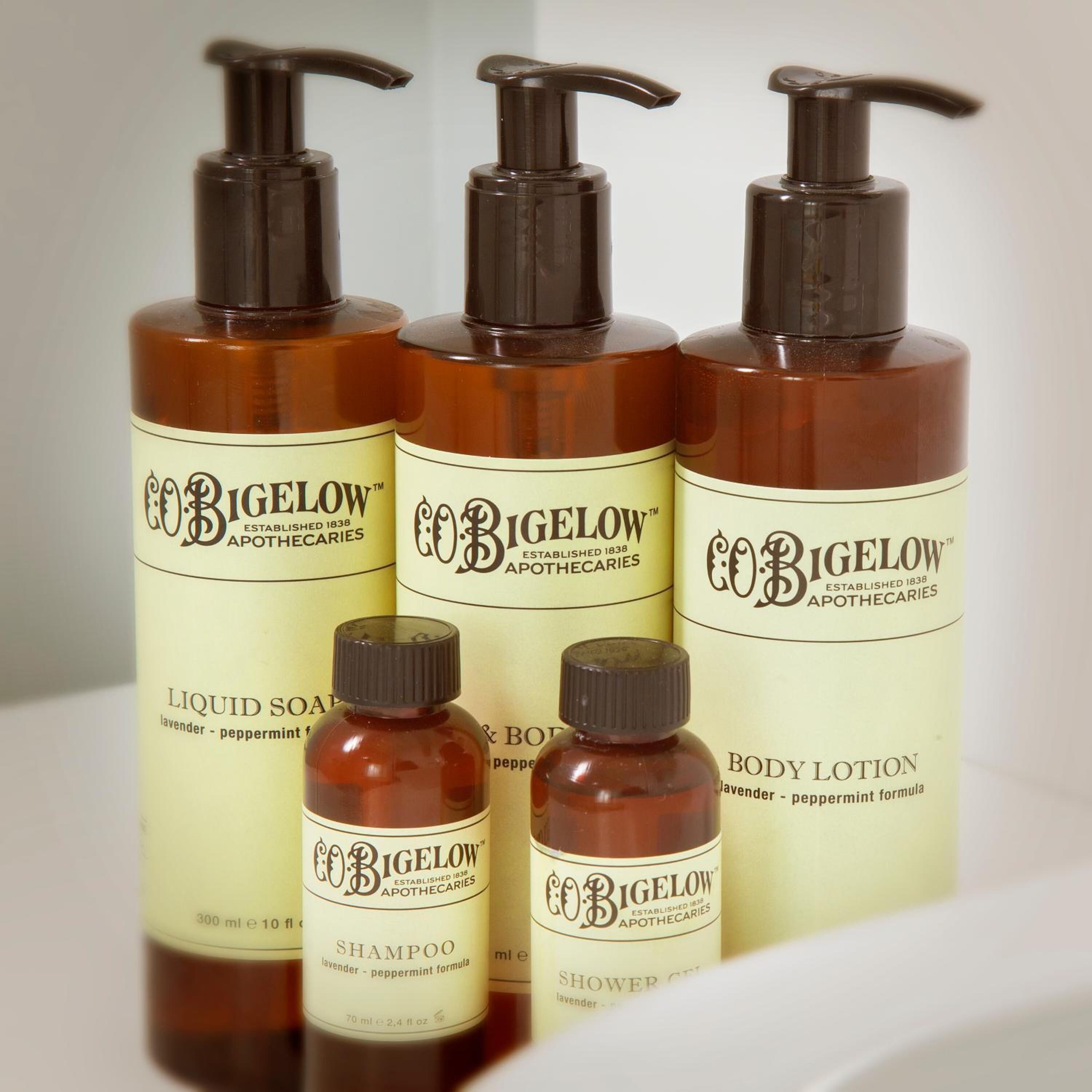 Four bottles of Bigelow body care products, including liquid soap, shampoo, and body lotion, arranged on a shelf.