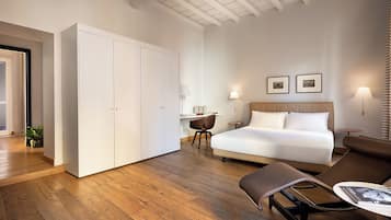 Une chambre d’hôtel avec un grand lit, un bureau, une chaise et une armoire.