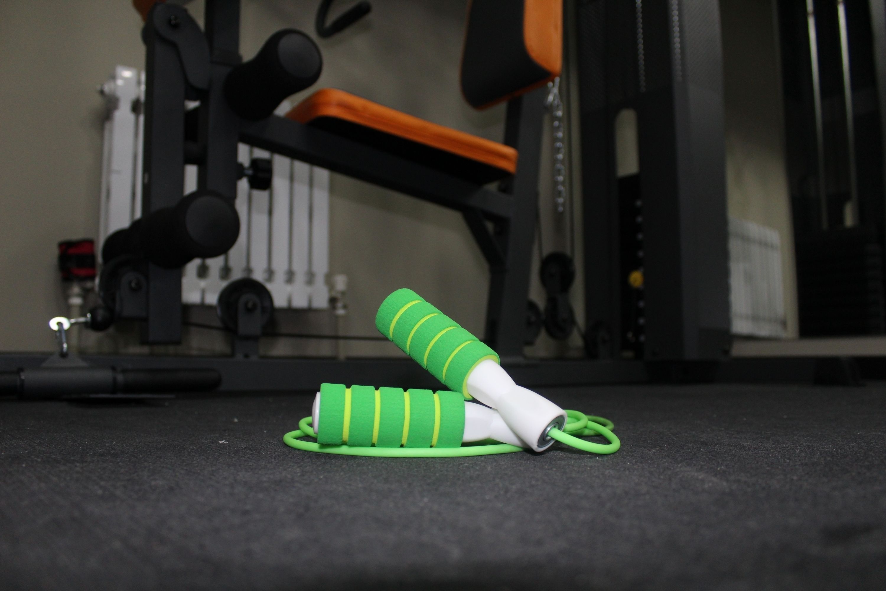 A green resistance band on a gym floor.
