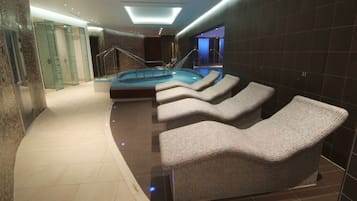 Relax in the central hot tub surrounded by lounge chairs and a glass-enclosed shower area.