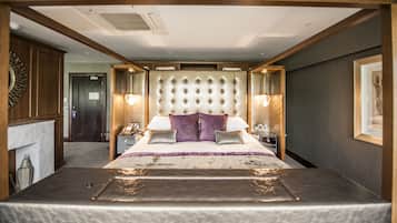 A spacious bedroom with a large bed, a tufted headboard, bedside lamps, and a nightstand.