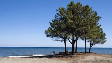 Een privéstrand, ligstoelen aan het strand