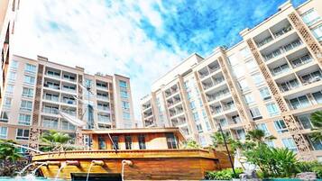 A hotel with multiple high-rise buildings, a swimming pool, and a wooden boat.