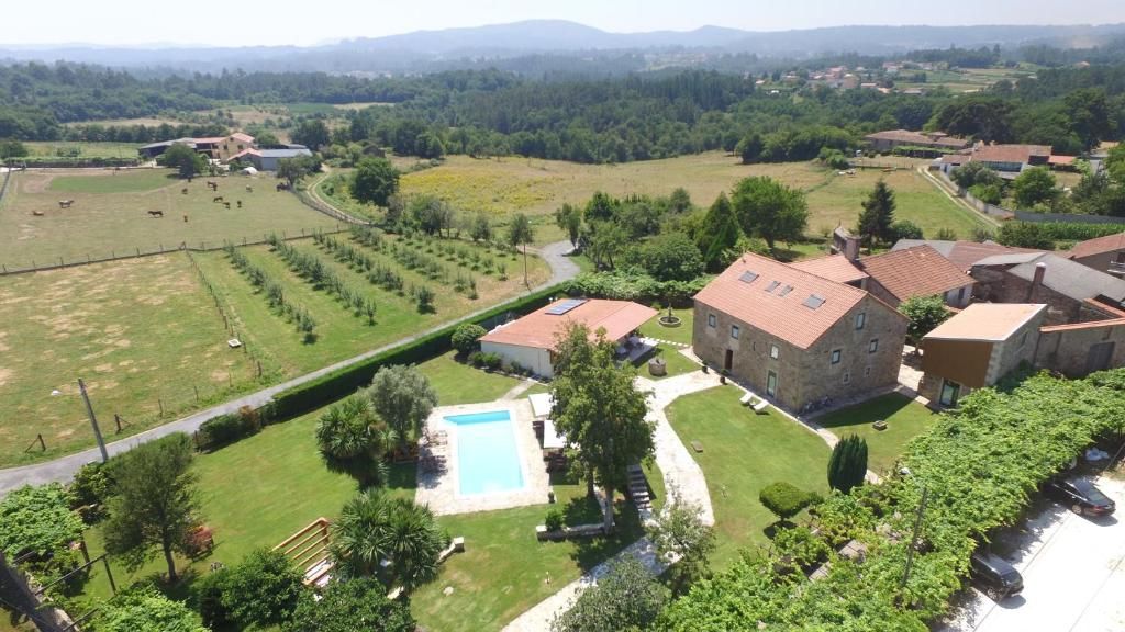 Una propiedad rural con piscina, un edificio grande y campos aledaños.