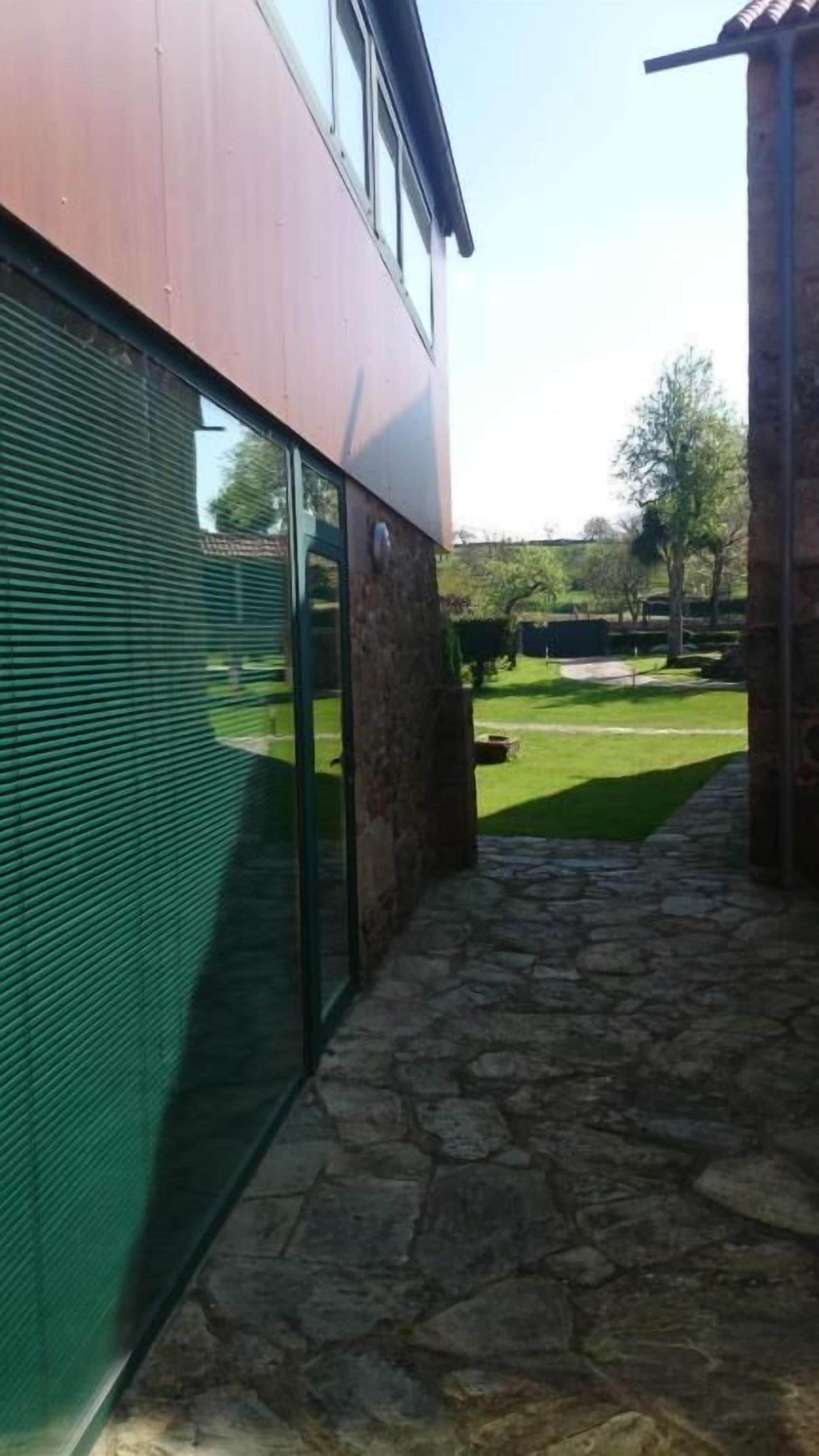 A modern building with a stone pathway leading to a green lawn.