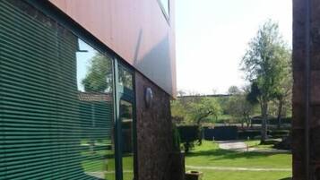 Un edificio moderno con un camino de piedra que conduce a un césped verde.