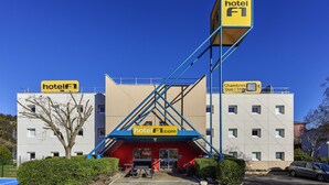 Un hotel con un llamativo letrero azul y amarillo, entrada roja y un diseño arquitectónico moderno.