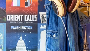Una chaqueta vaquera con auriculares colgando, y un cartel de fondo que anuncia la Conferencia Turística Oriental en Washington.