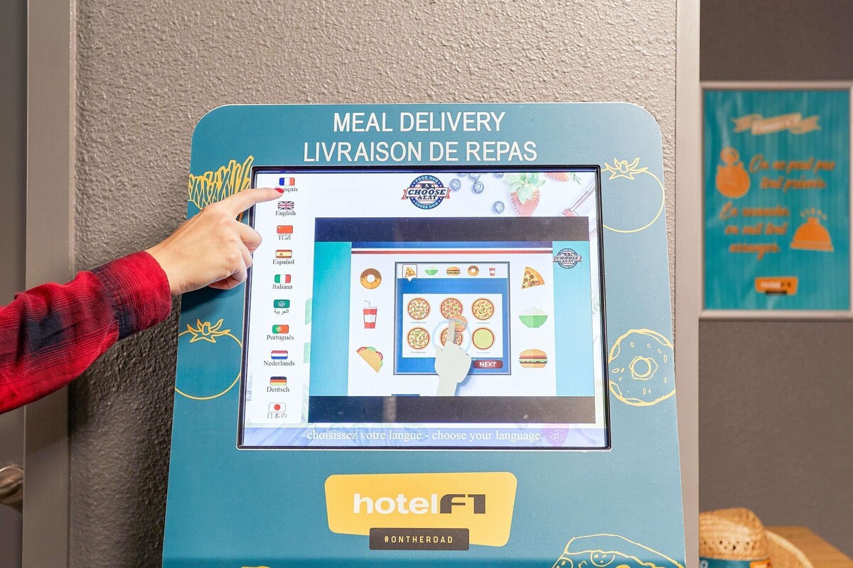 Ein Touchscreen-Kiosk mit Speisekarten für Essenslieferungen in verschiedenen Sprachen, der eine Auswahl an Speisen zeigt.