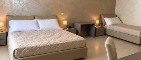 A hotel room with a large bed, two bedside tables, a desk, and a chair.