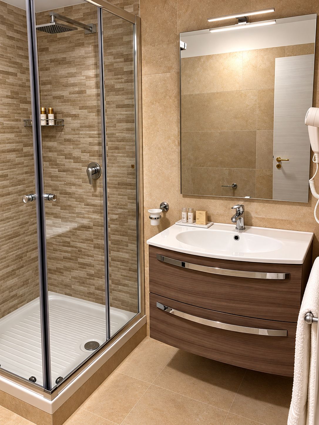 A modern bathroom with a glass-enclosed shower, a vanity with a large mirror, and a towel rack.
