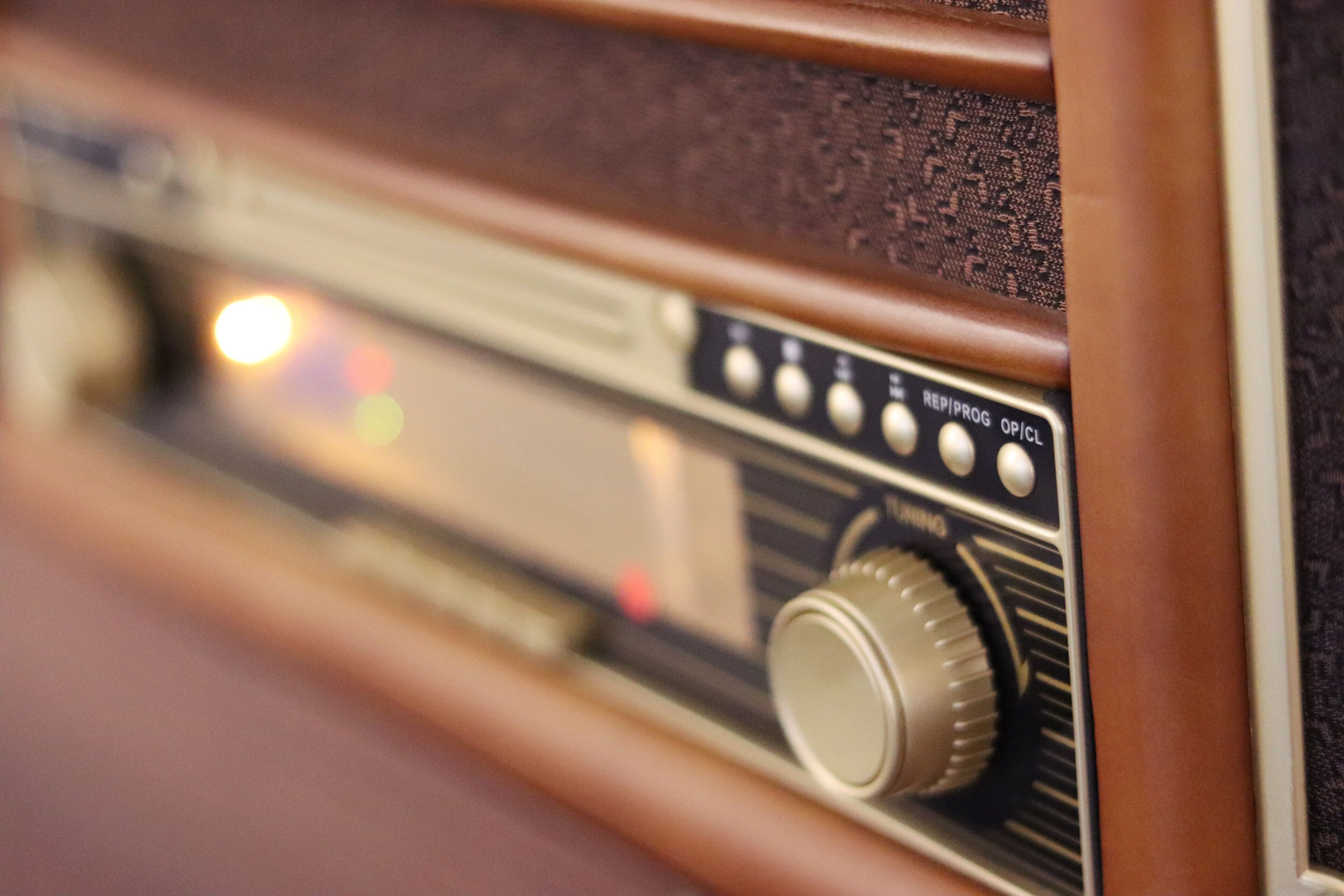Gros plan d’une radio ancienne, dotée d’un cadre en bois et d’un bouton de réglage.