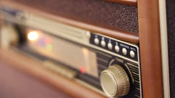 A close-up of a vintage radio with a wooden frame and a control knob.