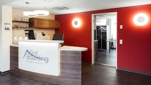 Una recepción de diseño moderno, una pared de acento de madera y una pared roja con iluminación circular.