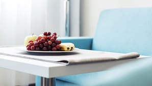Una mesa con un plato de fruta en una habitación de hotel moderna.