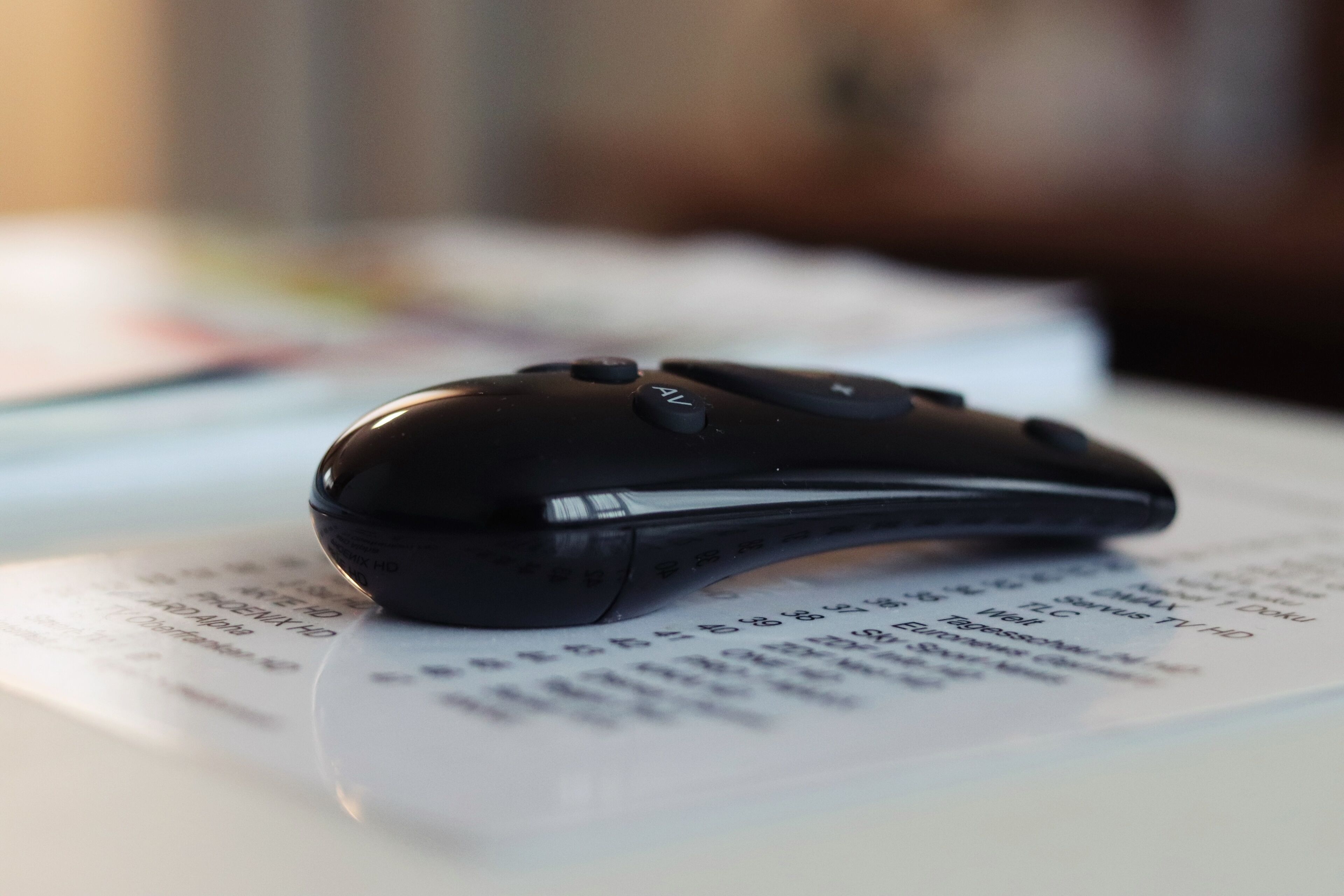 Um rato de computador preto sobre um documento com texto impresso.