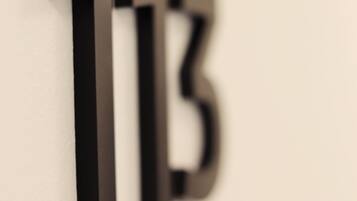 Un primo piano della lettera 'B' nera su una parete bianca.