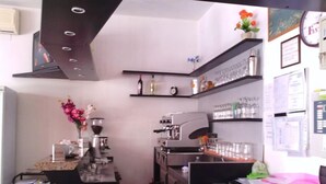 Una cocina pequeña y moderna con una cafetera, un lavabo y una encimera con varios objetos.