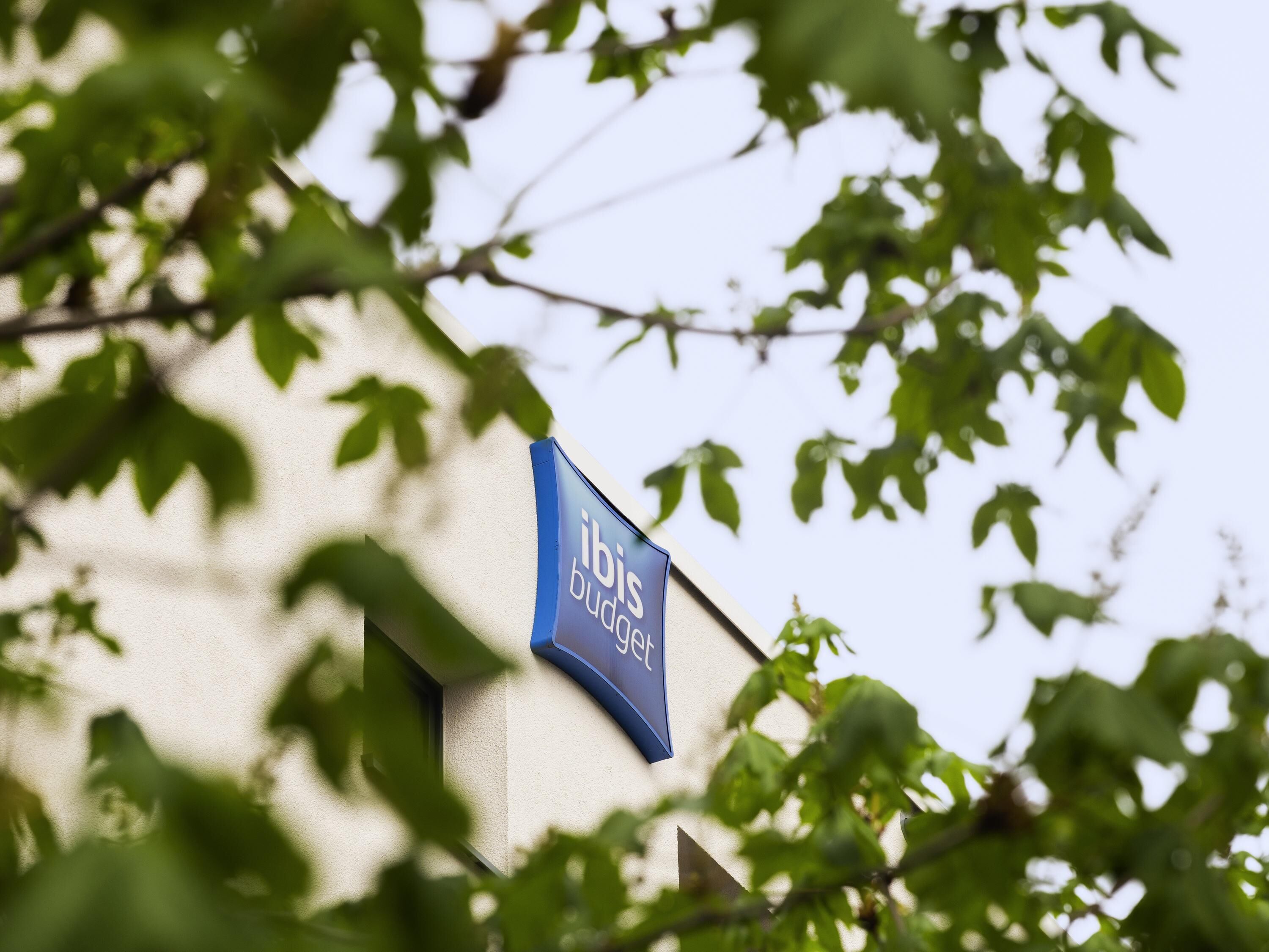 A building with a sign that reads 'ibis budget hotel.'