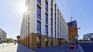 A modern building with a flat facade, large windows, and a brick base. - ibis budget Ludwigsburg (Ludwigsburg)