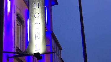 A hotel sign with the name "HOTEL" in capital letters, mounted on a building facade.