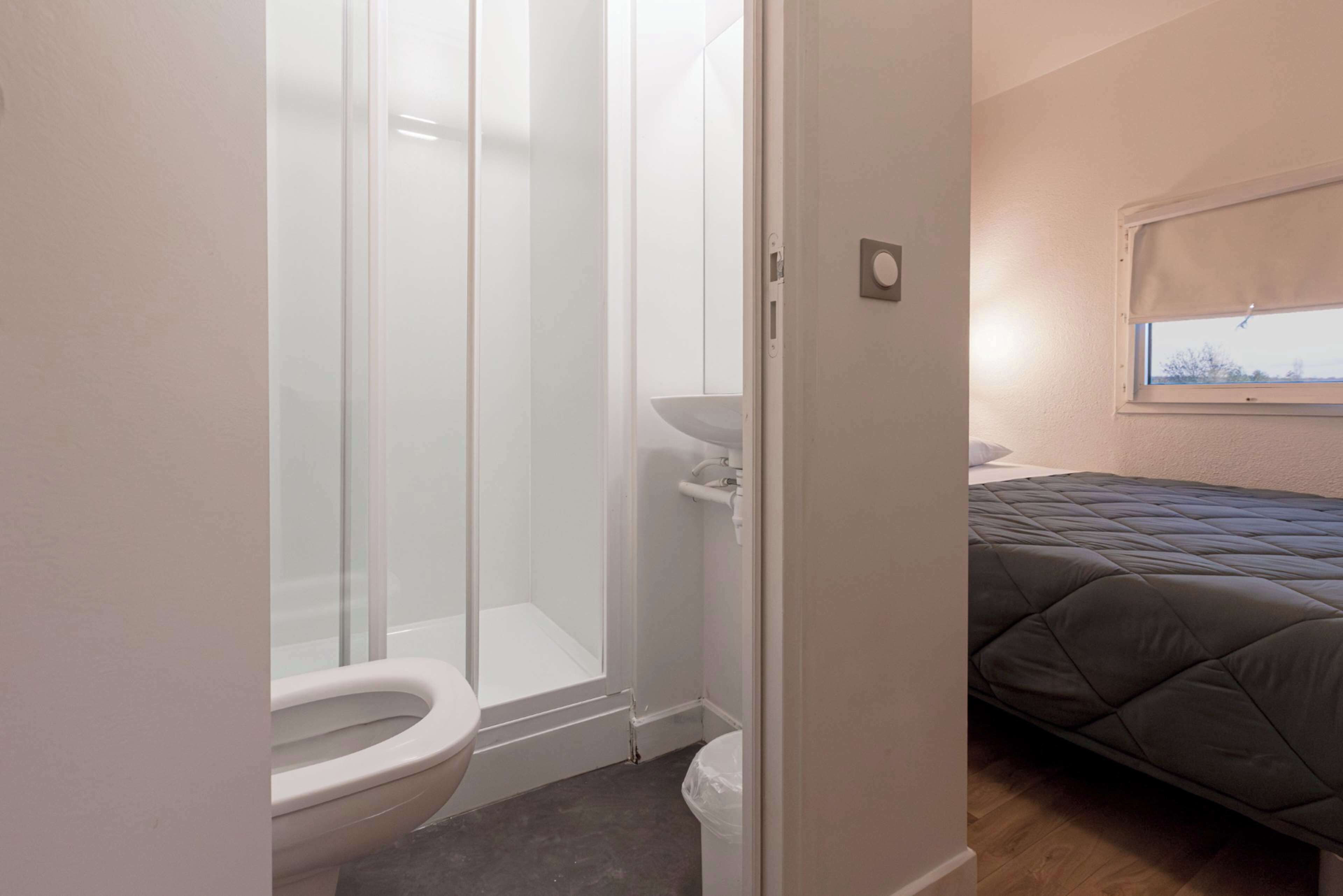 Un baño con cabina de ducha de vidrio, inodoro y lavabo.