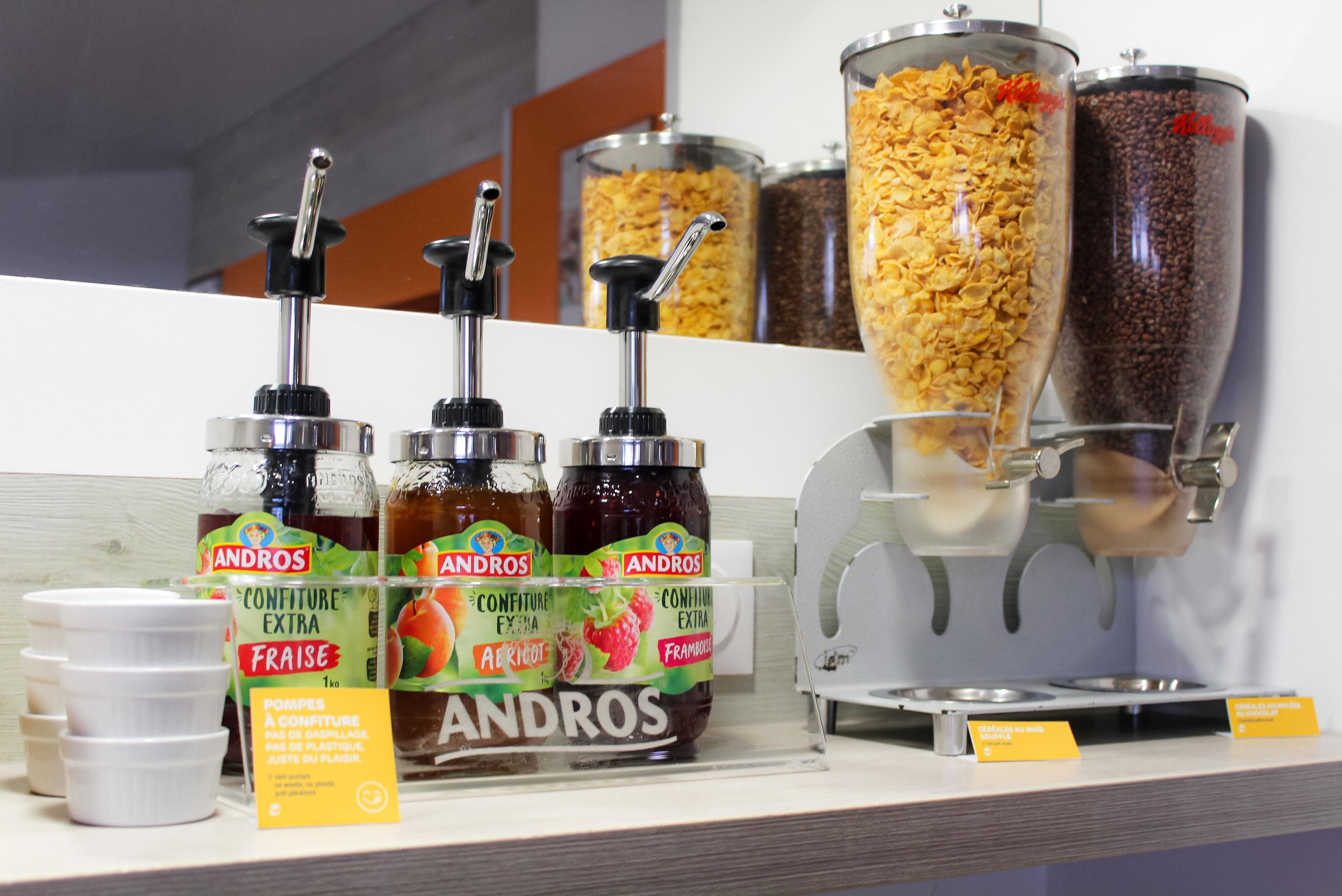Un angolo self-service con salse Andros e un distributore di caffè.
