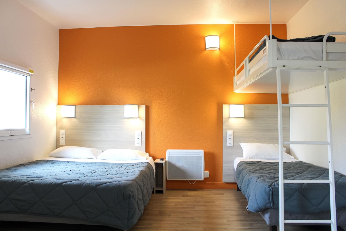 A room with two beds, a bunk bed, a heater, and a window.