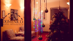 A hotel entrance with a Christmas tree decorated with ornaments and lights.
