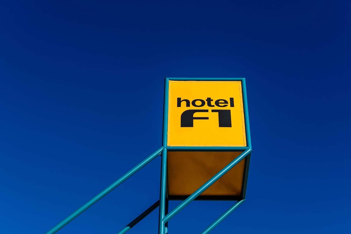 Un panneau jaune sur lequel on peut lire les mots « hÎtel » et « FT », le tout sur un fond bleu.