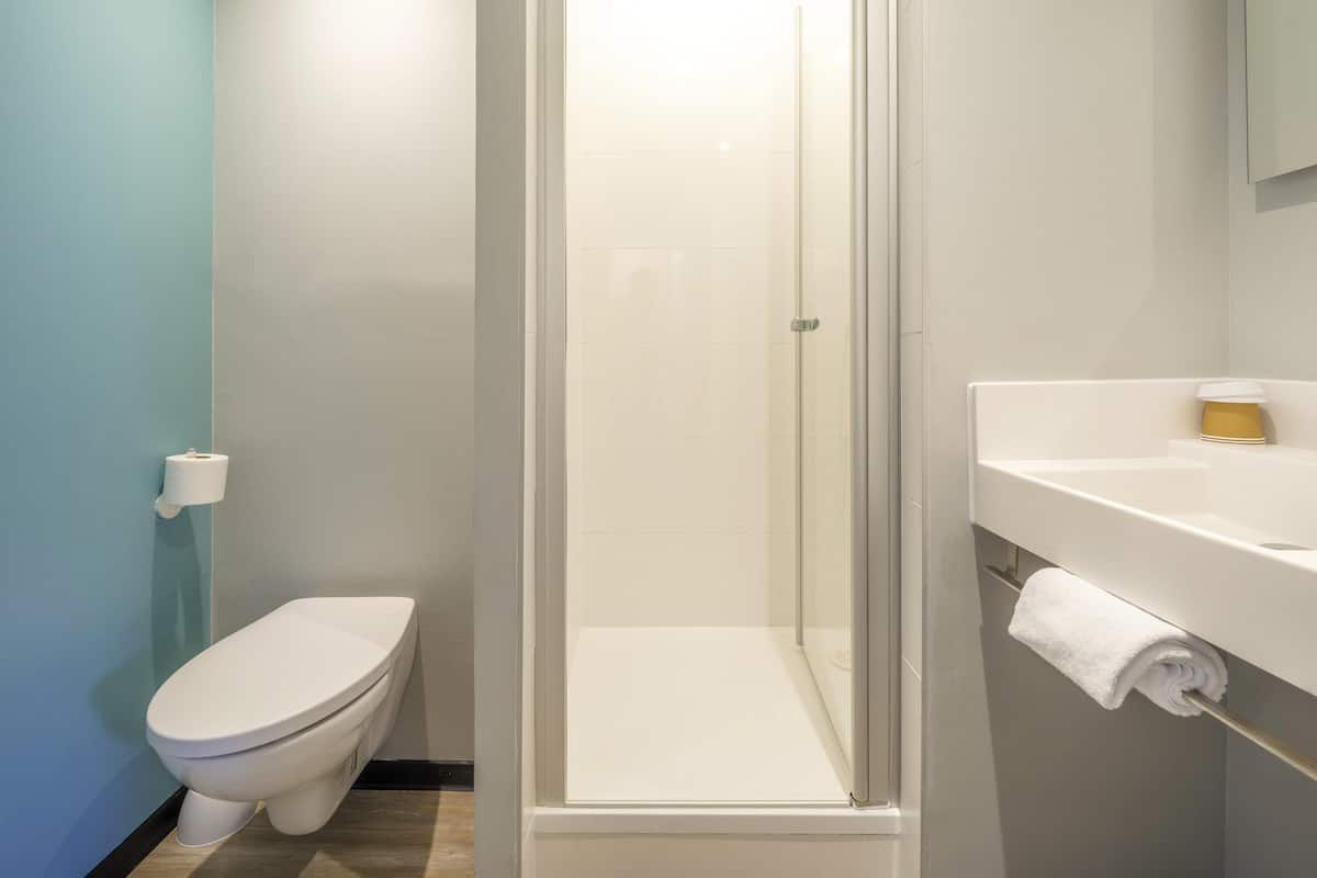 Un baño con inodoro, ducha y lavabo.