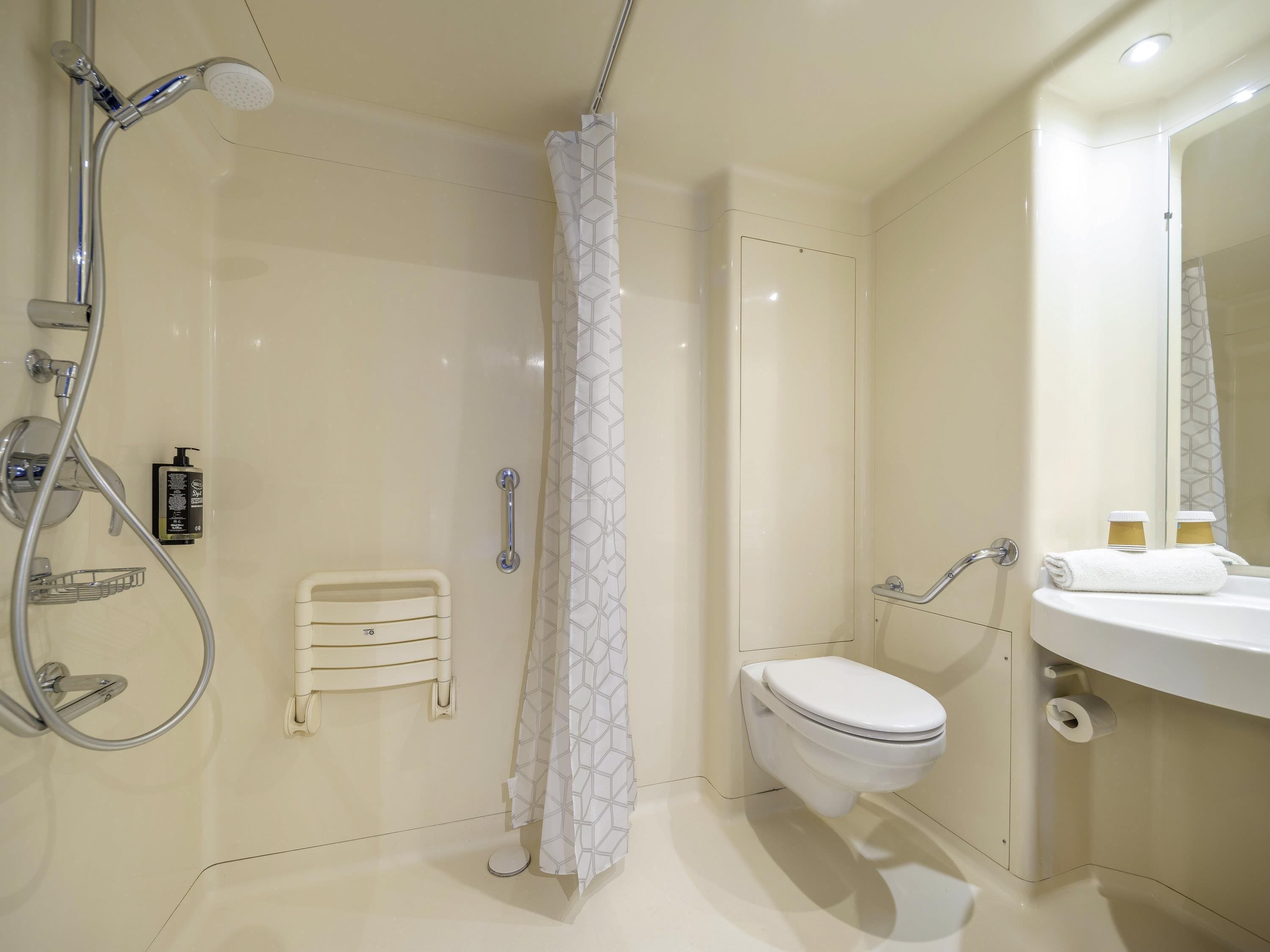 A modern bathroom with a shower, toilet, and sink.
