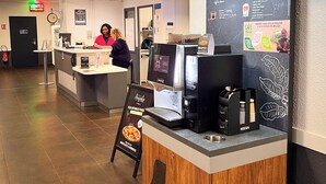 Un espace dédié au café Nescafé, comprenant un panneau affichant le menu, une machine à café et une affiche annonçant une offre spéciale.